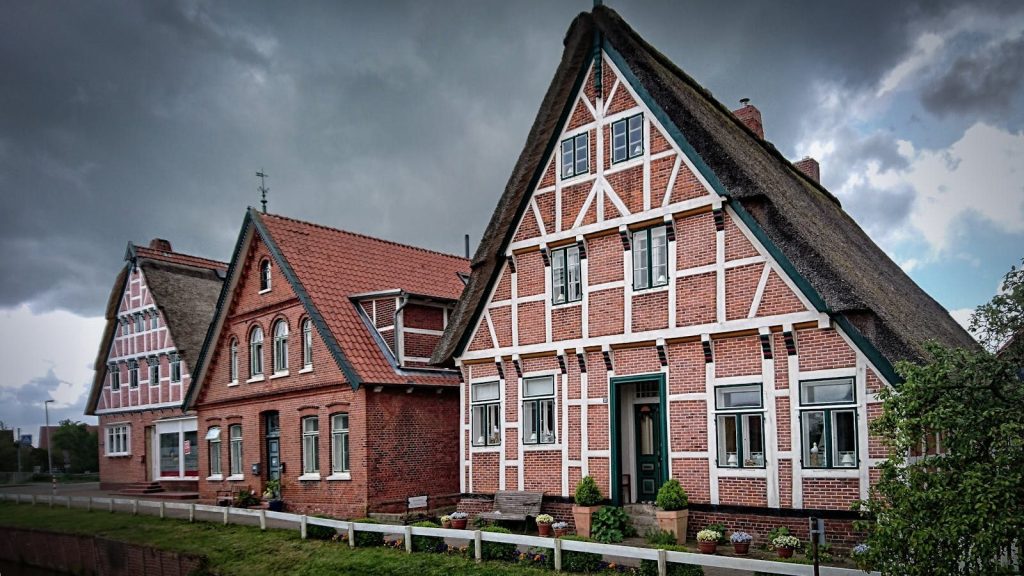 Scenic view of historic half-timbered houses in Jork, Germany under an overcast sky.