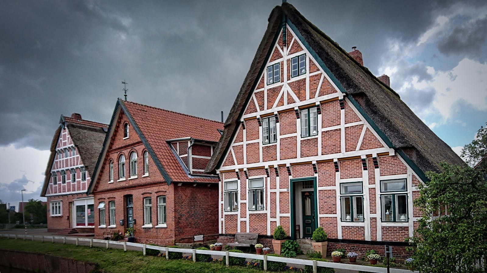 Scenic view of historic half-timbered houses in Jork, Germany under an overcast sky.